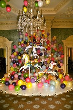 a carousel is surrounded by balloons and chandeliers