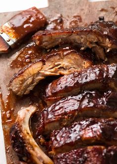 barbecue ribs covered in bbq sauce on a cutting board