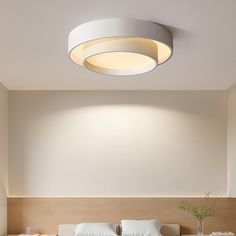 a bed room with a neatly made bed and a round light fixture above the bed