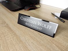 a desk with a sign that says christian wolf account on it next to a laptop