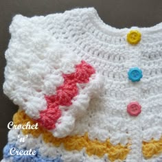 a crocheted white shirt with colorful buttons on it