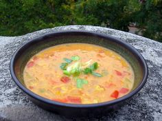 a bowl of soup sitting on top of a rock