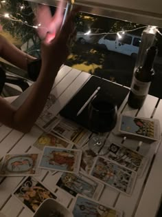 a person sitting at a table with some cards on it and a wine glass in front of them