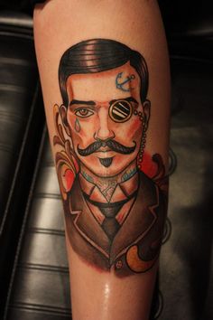 a man with a mustache and eye patch on his leg is depicted in this tattoo