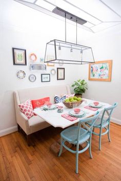 a dining room table with plates and bowls on it in front of a white couch