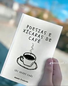 a person holding up a book with a drawing of a cup of coffee on it