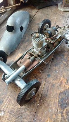 an old metal toy car sitting on top of a wooden floor