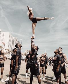 a group of cheerleaders standing around each other in front of a blue sky