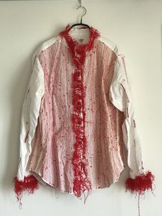 a red and white shirt hanging on a wall