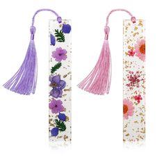 two bookmarks with flowers and tassels on them, one in pink and the other in purple