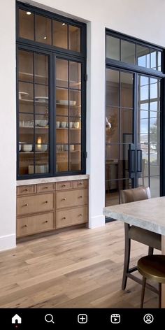 a dining room with wooden floors and large windows