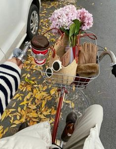 a person is sitting on a bike with flowers in the basket and other items inside