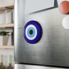 an eyeball sticker on the side of a stainless steel refrigerator with shelves in the background