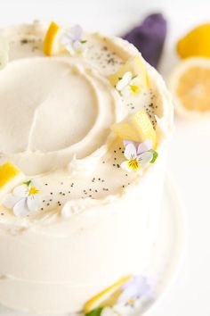 a close up of a cake on a plate with flowers and lemons around it