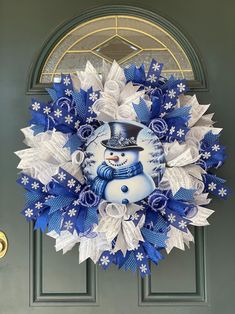 a blue and white wreath with a snowman on it