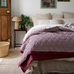 a bed in a bedroom with a red and white checkered comforter