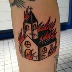 a tattoo with a church on it that has flames coming out of it