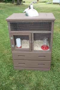 a bird cage sitting on top of a grass covered field