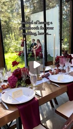 a table set with plates and place settings for two people sitting at the table in front of a large window