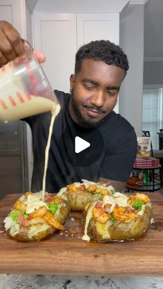 the man is pouring sauce on baked potatoes