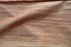 a close up view of the fabric in brown and pink tones, with small stripes on it