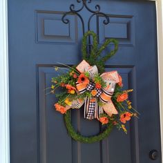 an orange and black wreath on a blue door