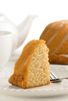 a piece of cake sitting on top of a white plate next to a cup and saucer