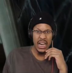 a man wearing headphones and making a surprised face