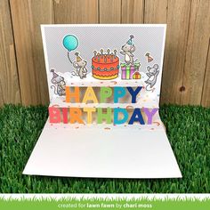 a birthday card with the words happy birthday on it in front of a wooden fence