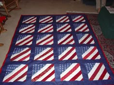 an american flag quilt is laying on the floor