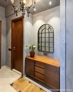 an entryway with a wooden cabinet and chandelier