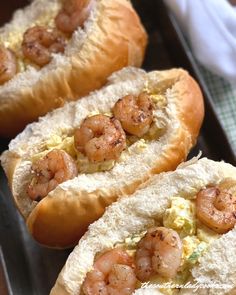 there are three hot dogs with shrimp on them