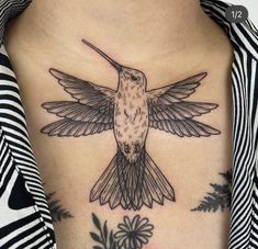 a hummingbird tattoo on the back of a woman's upper arm and chest