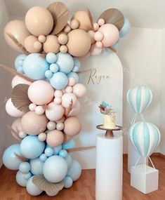 a bunch of balloons that are on the ground in front of a cake and other decorations