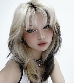 a woman with long blonde hair wearing a white shirt and black bra top is posing for the camera