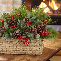 a basket filled with pine cones and evergreens sitting on top of a wooden table