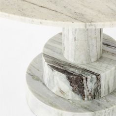 a white marble table top with an intricate design on it's base and bottom