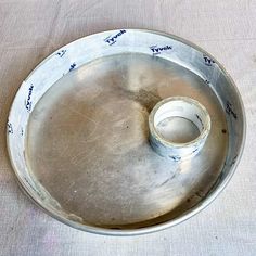 an empty metal tray on a table with writing on the side and a tape sticking out of it