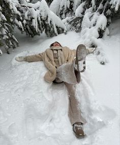 a man laying in the snow next to a parking meter