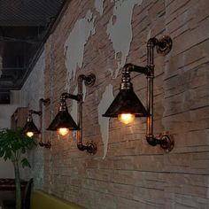 three lights are on the side of a brick wall