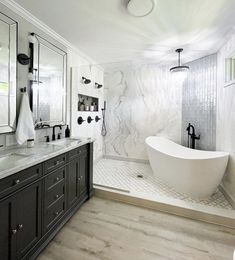 a large white bath tub sitting next to a walk in shower