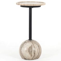 a marble table with a black metal base and a white marble ball on the top