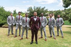 a group of men in suits standing next to each other on top of a lush green field