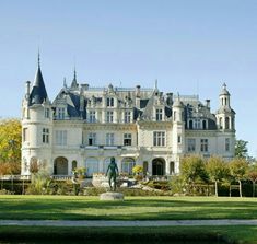 a large castle like building sitting on top of a lush green field