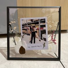 a photo frame with flowers and a vase