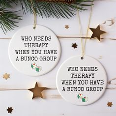 two ceramic ornaments with words on them hanging from a christmas tree branch, one says who needs therapy when you have a bunco group