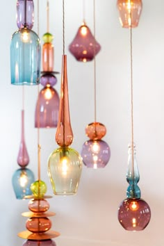 many different colored glass lights hanging from strings