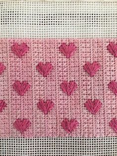 a close up of a knitted piece of cloth with hearts on the front and back