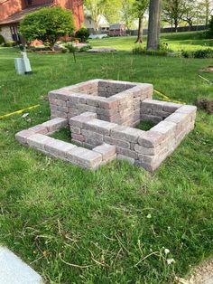 a brick fire pit sitting in the grass