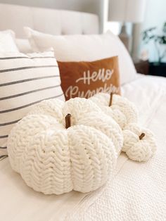 two knit pumpkins on a bed with the words cozy pumpkin pillow crochet pattern